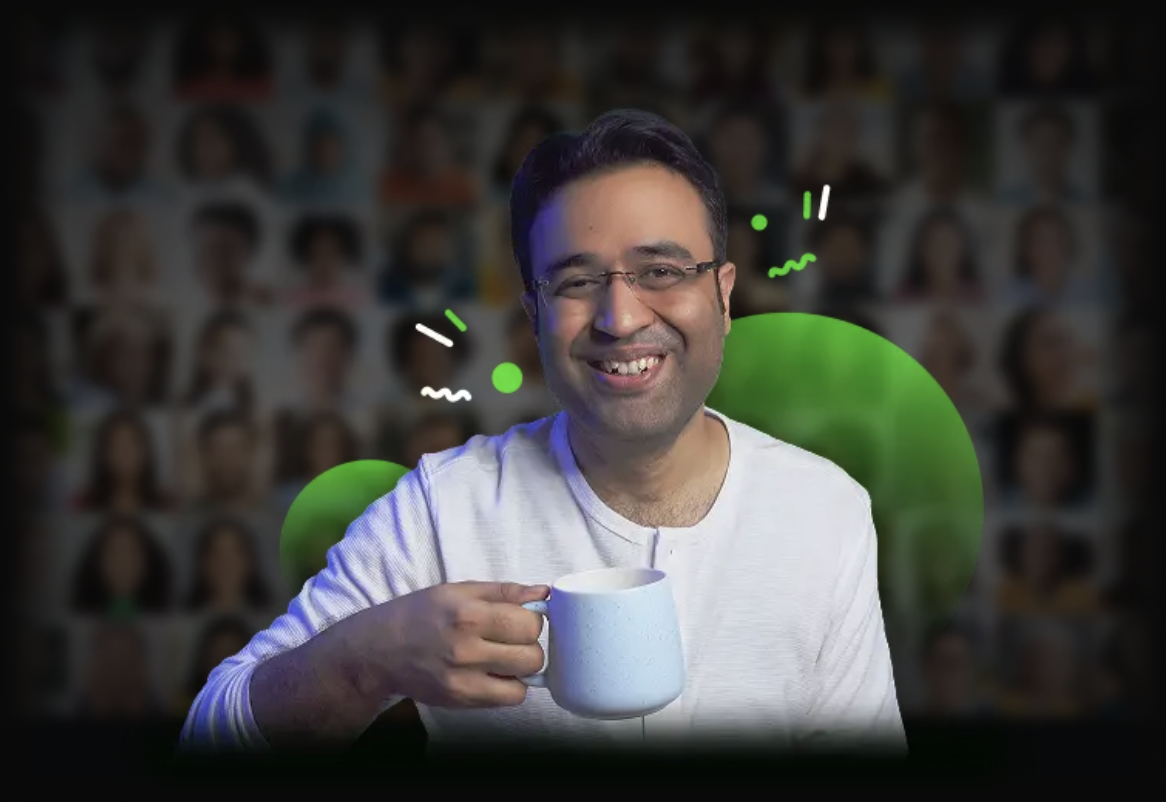 Sannidhya Baweja holding a coffee mug in front of an audience wall